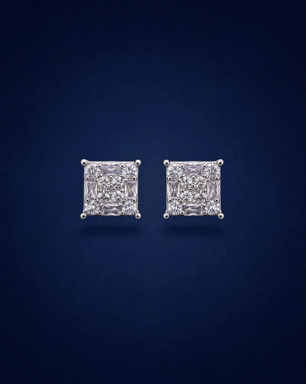 Pair of diamond stud earrings on a dark blue background