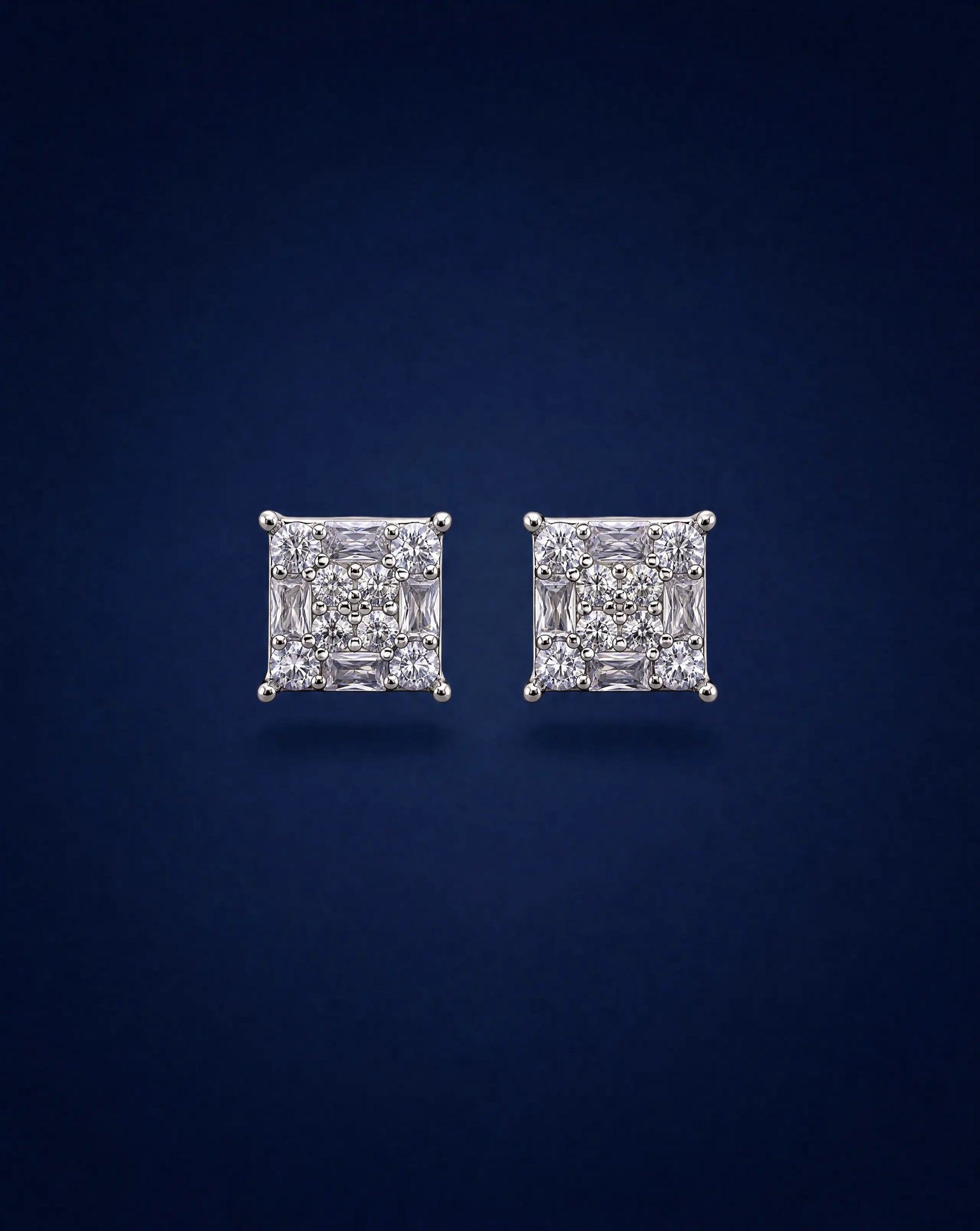 Pair of diamond stud earrings on a dark blue background