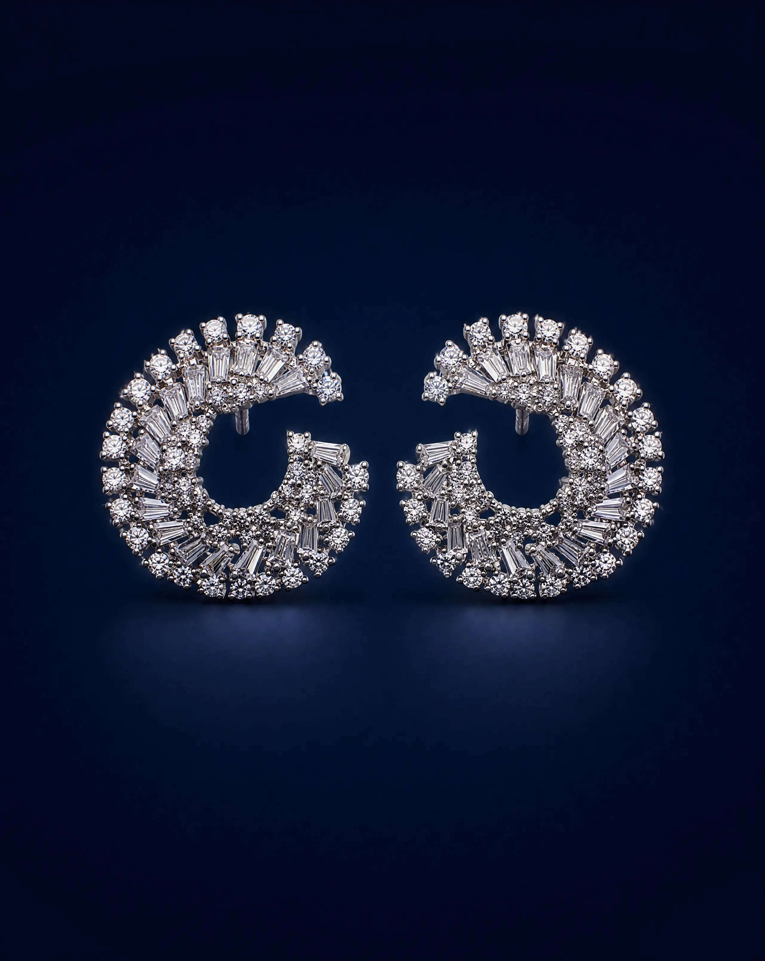 Pair of diamond earrings on a dark blue background