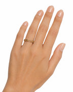 Hand wearing a gold ring on a white background