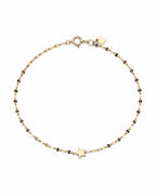 Gold bracelet with star charm on a white background