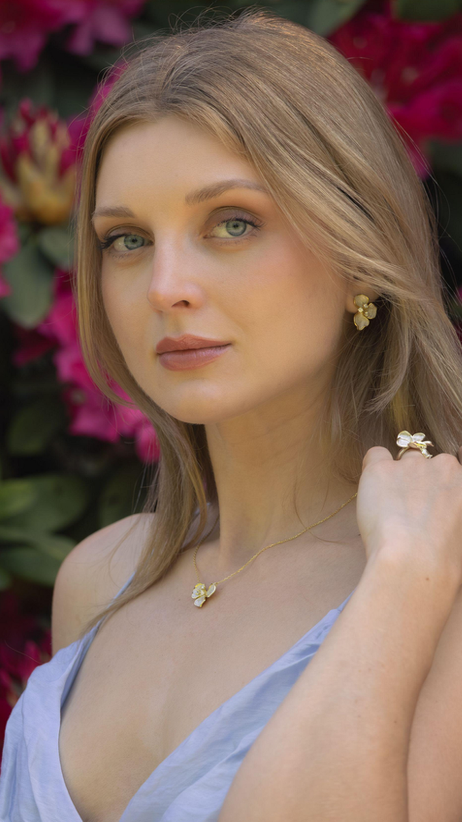 Woman with floral earrings and necklace against a floral background