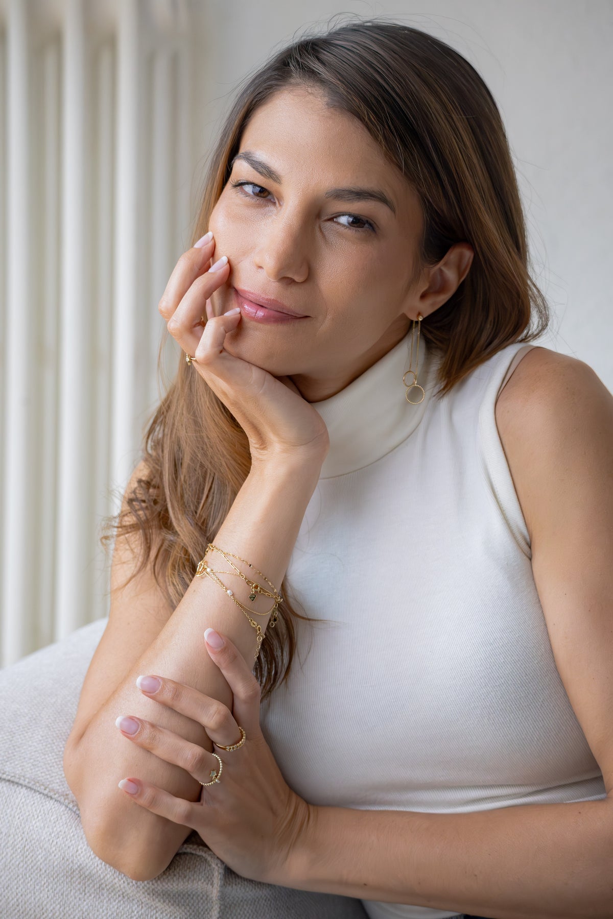 The girl is wearing gold jewelry, gold bracelets, earrings and rings